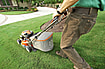 Man mowing green lawn with push mower